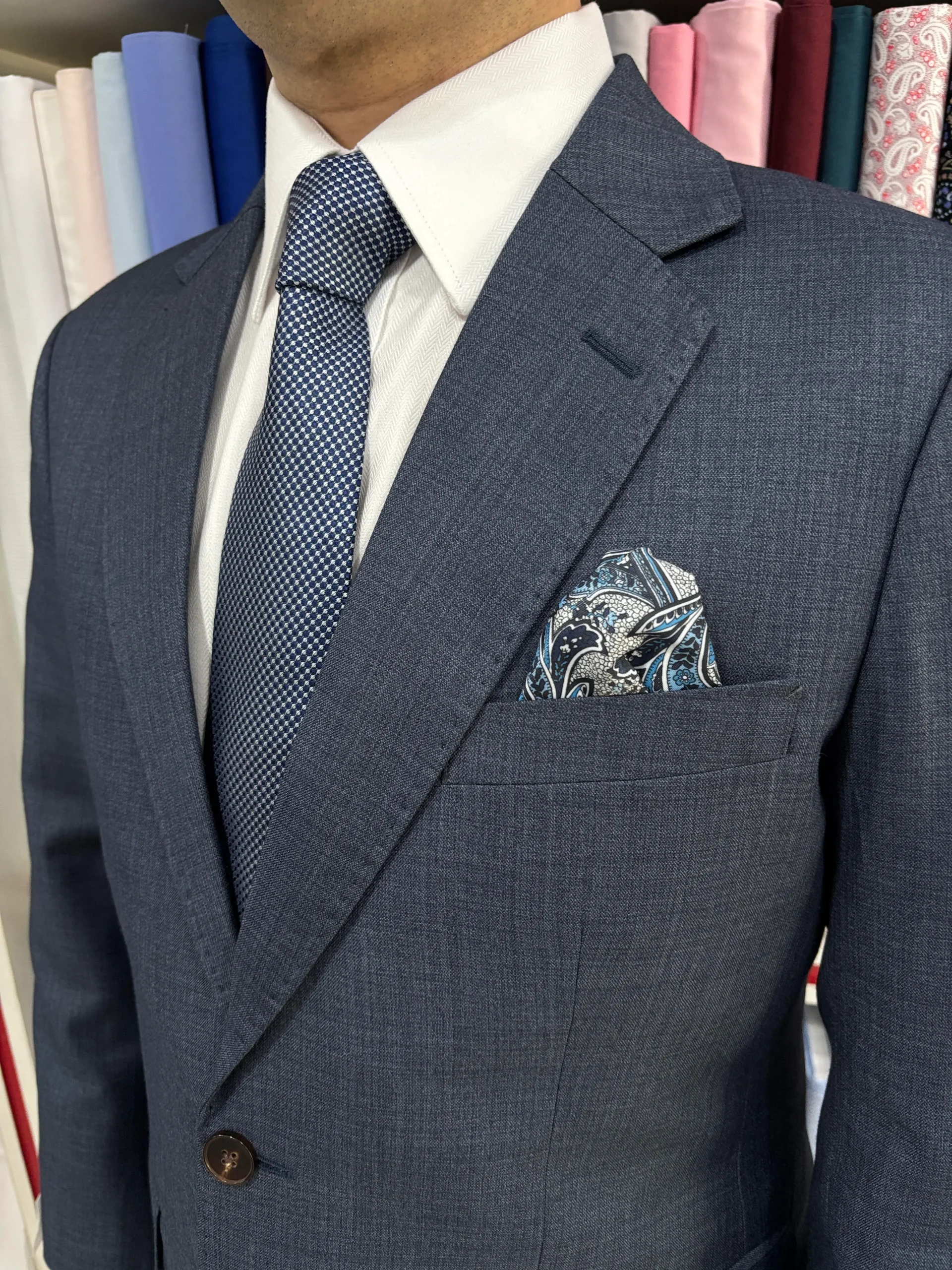 Close view of a tailored suit shoulder and collar during a fitting at Jhasper Fashion