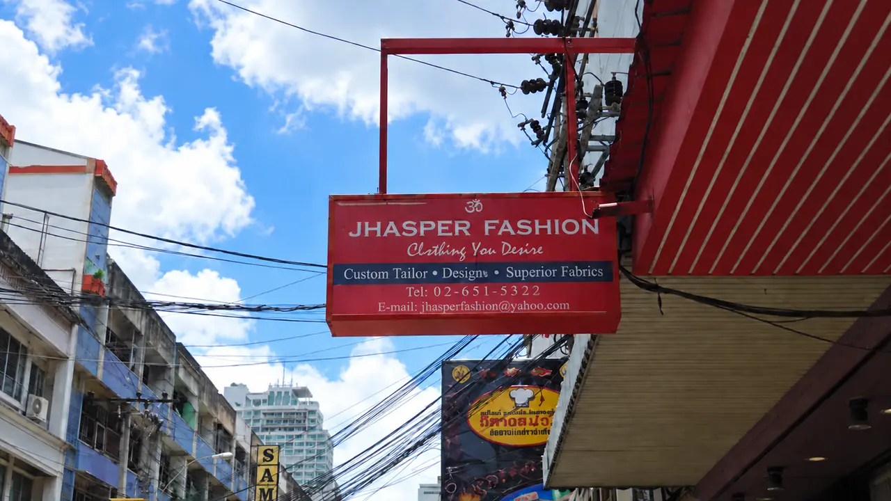 Red Jhasper Fashion hanging sign above the street beside the shop building.